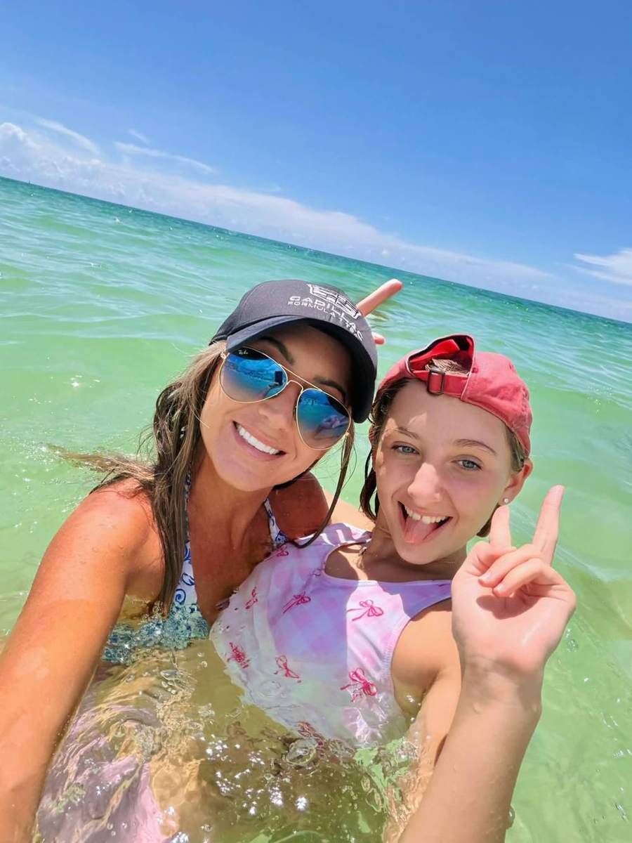 Kendra and her daughter smiling in the clear green Gulf water