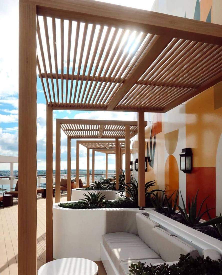 Wooden pergola over lounge seating on an upper deck