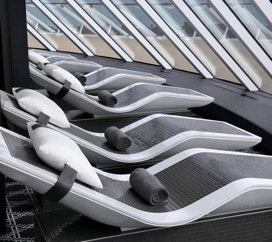 Heated tile loungers in a row facing angled windows