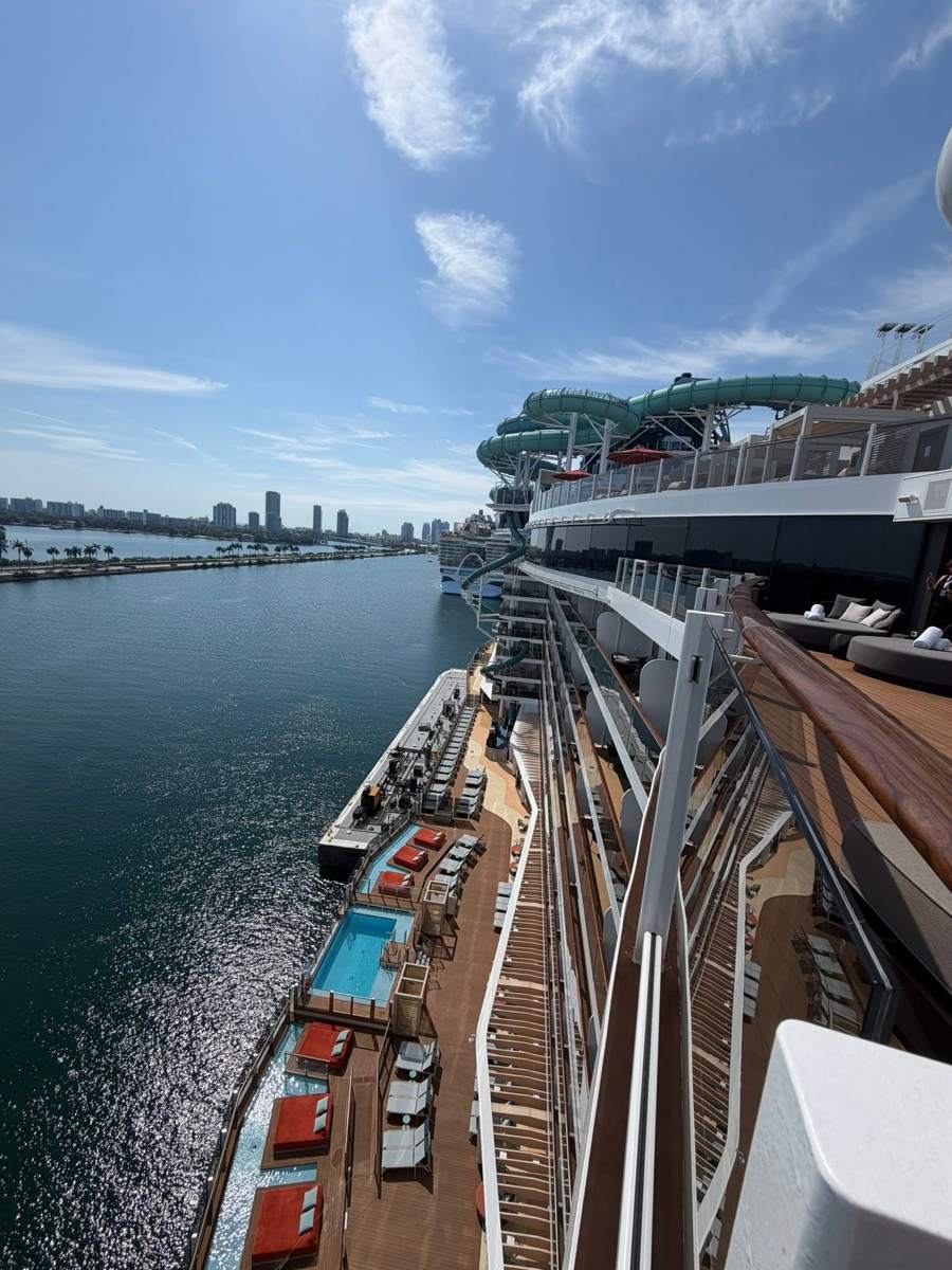 Looking down from the ship at pool decks beside the water