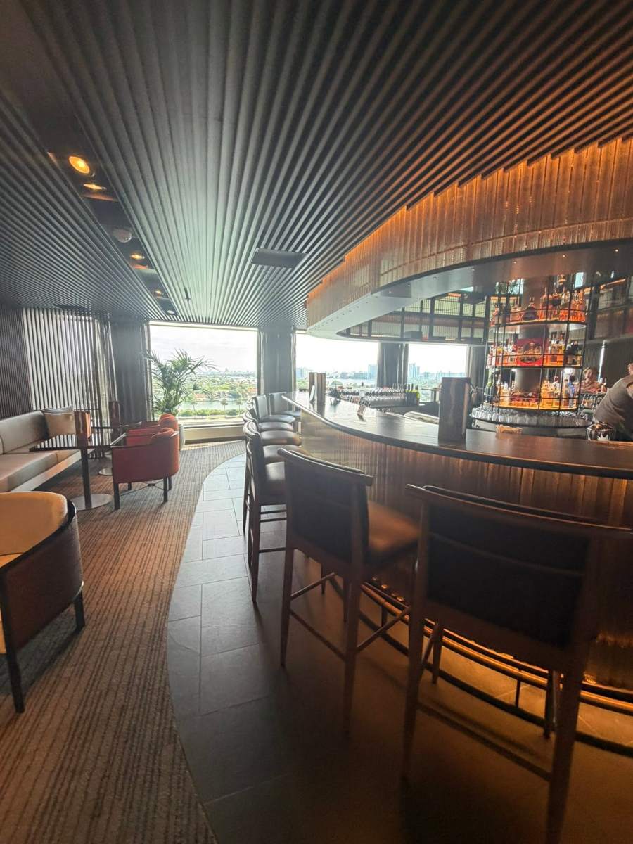 A curved bar lounge with warm lighting and a skyline view