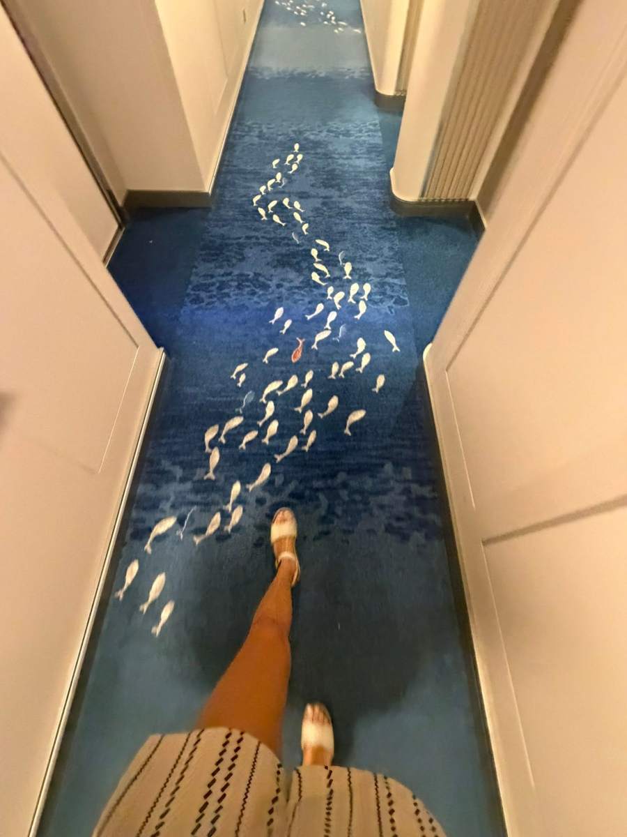 Fish pattern on a hallway carpet swimming toward the front of the ship