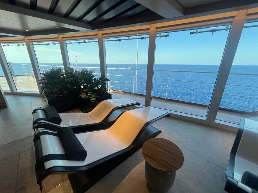 Lounge chairs facing floor-to-ceiling windows with an ocean view