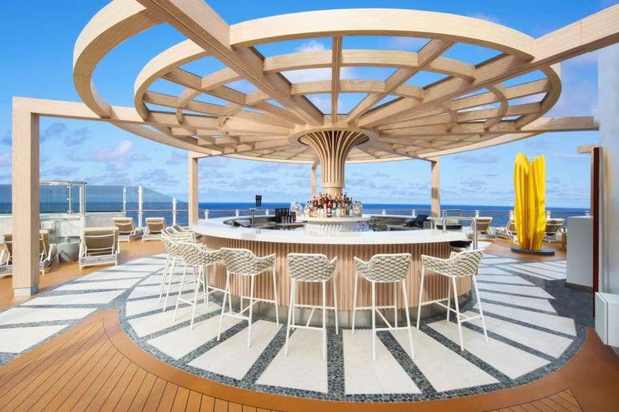 A round pergola over a circular bar on a sunny deck with ocean behind
