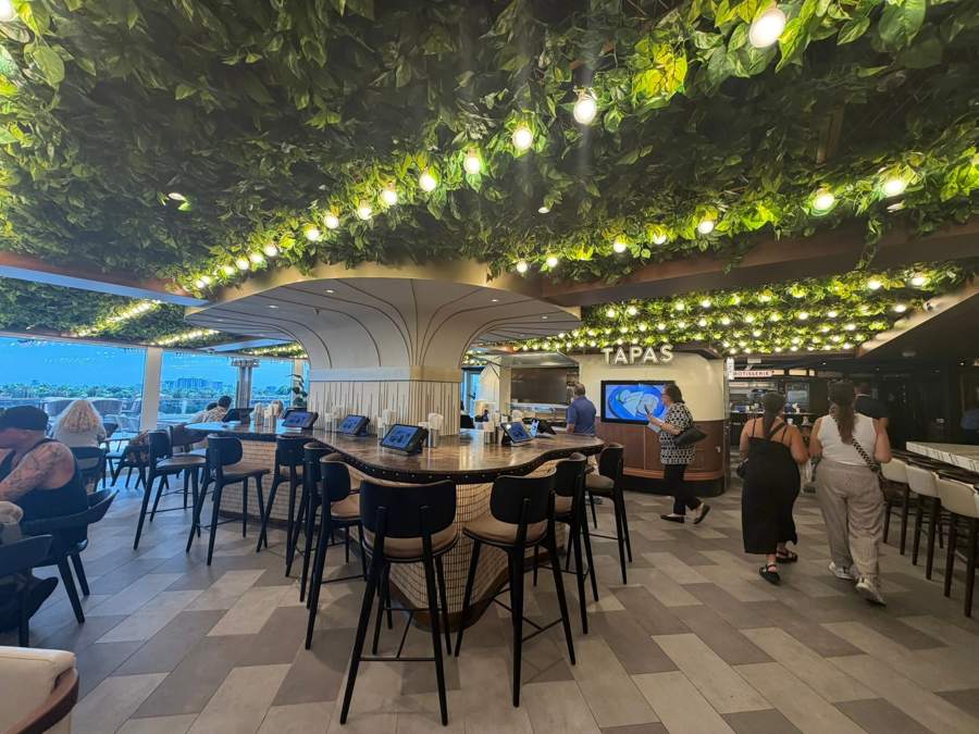 The Tapas area under a ceiling of green leaves and string lights